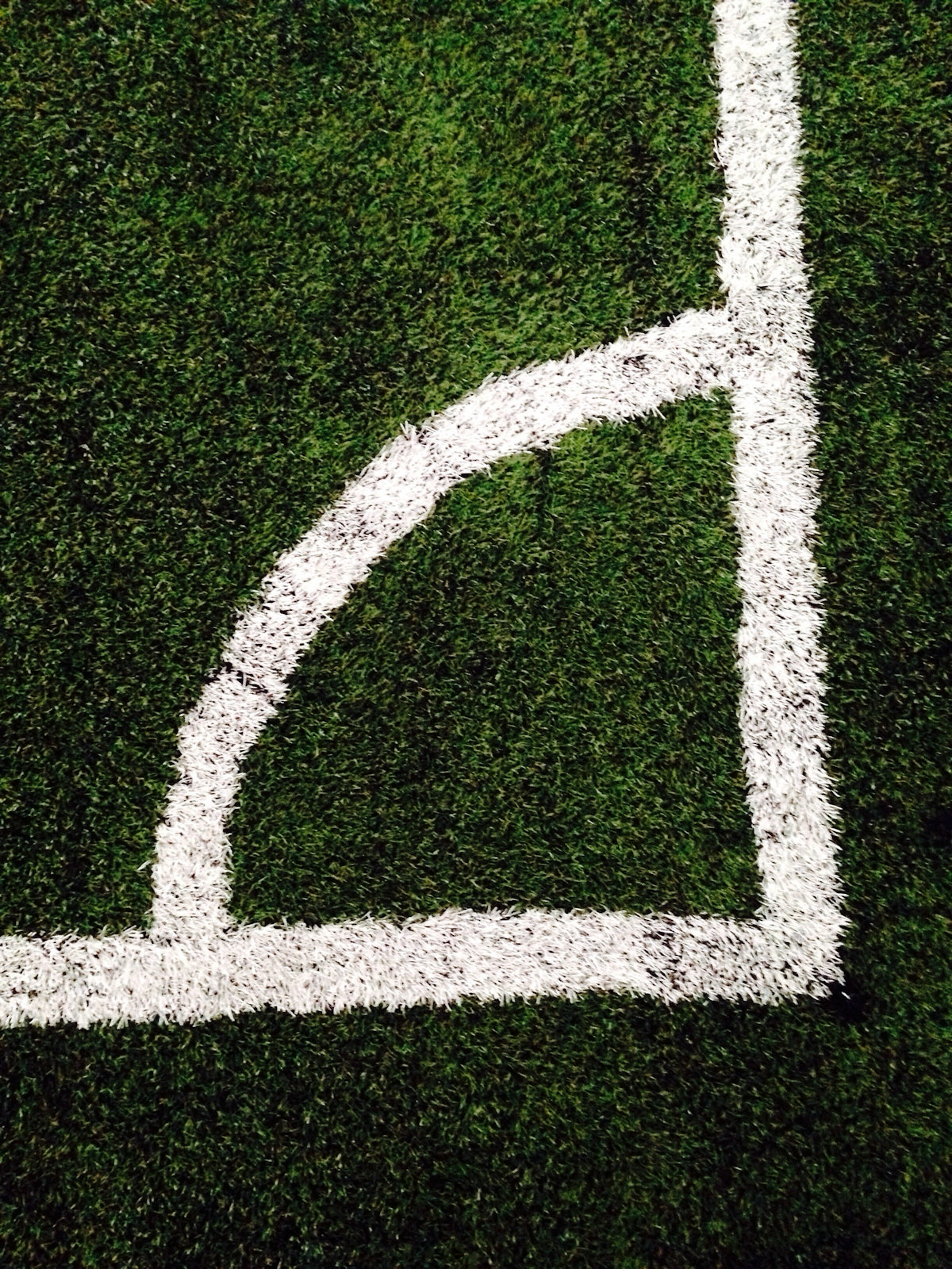 Close-up of a soccer field corner with white lines on green grass for step-by-step correct score bet tutorial